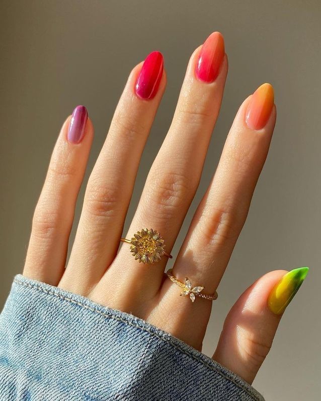 Mão branca com anéis e unha jelly colorida