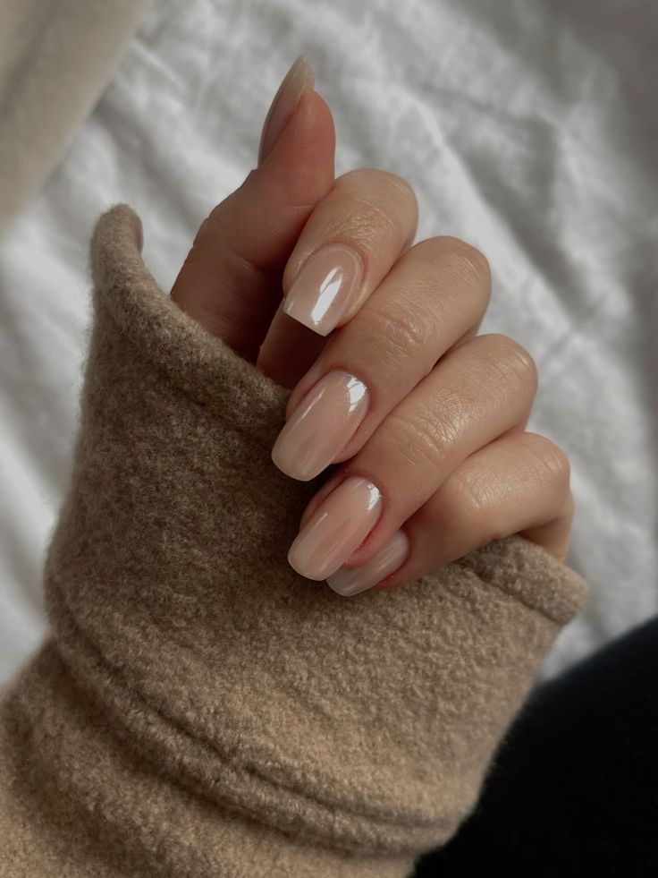 Mão branca fechada com unha simples e elegante nude