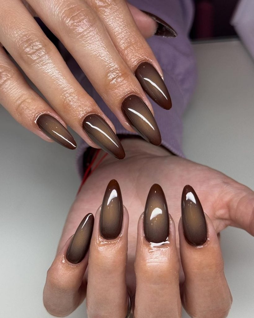 Mãos brancas com unha stiletto estilo aura marrom