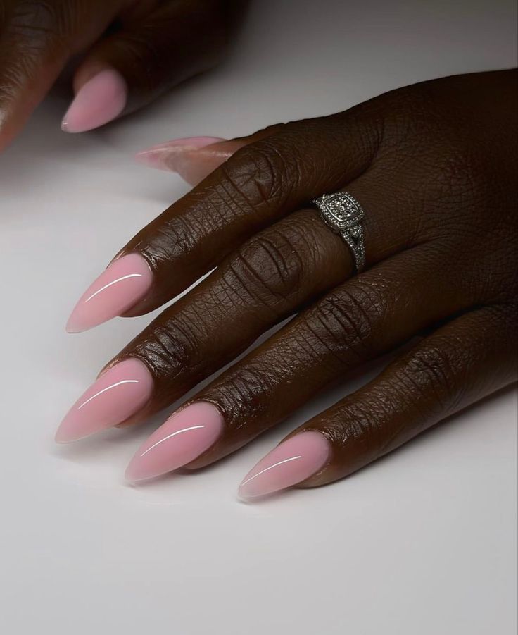Mão negra com anel e unha stiletto rosa bebê