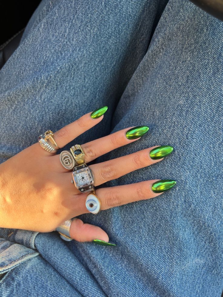 Mão branca com anéis e unha amendoada verde metálica