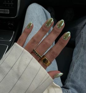 Mão branca com anéis e unha verde oliva perolada