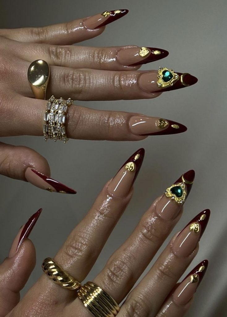 Mãos com anel abertas e unha francesinha vermelha com aplicações em 3D no dourado