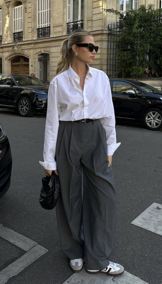Mulher usando camisa branca e calça de alfaiataria cinza