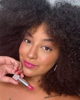 Mulher negra e jovem com batom rosa