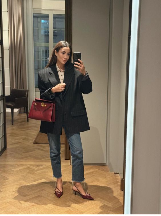 Mulher jovem usando blazer oversized, slingback e calça jeans reta