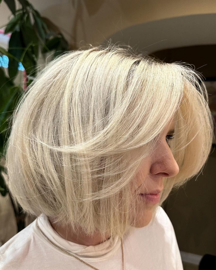 Mulher branca, loira, com cabelo curto escovado, no estilo bubble bob, com franja