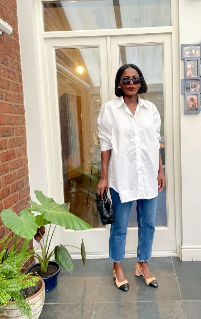 Mulher preta usando peças coringas (camisa branca e calça jeans reta)