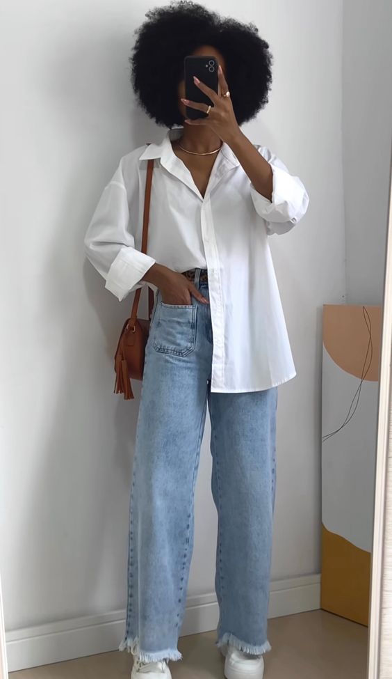 Mulher jovem negra usando peças coringas (camisa e calça jeans)