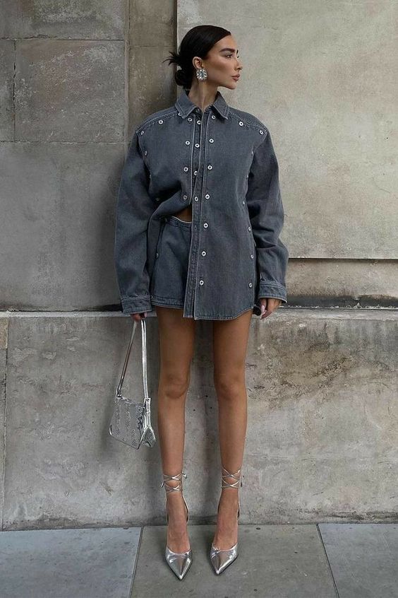 Mulher usando salto alto prata com bolsa prata e conjunto em denim