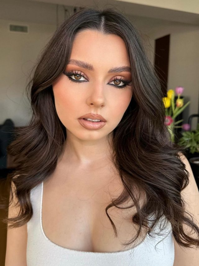Mulher branca com regata branca, cabelo escuro e maquiagem marrom com olhos cappuccino