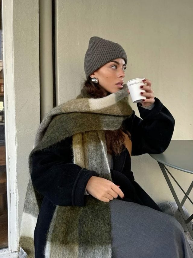 Mulher branca usando cachecol xadrez verde com marrom