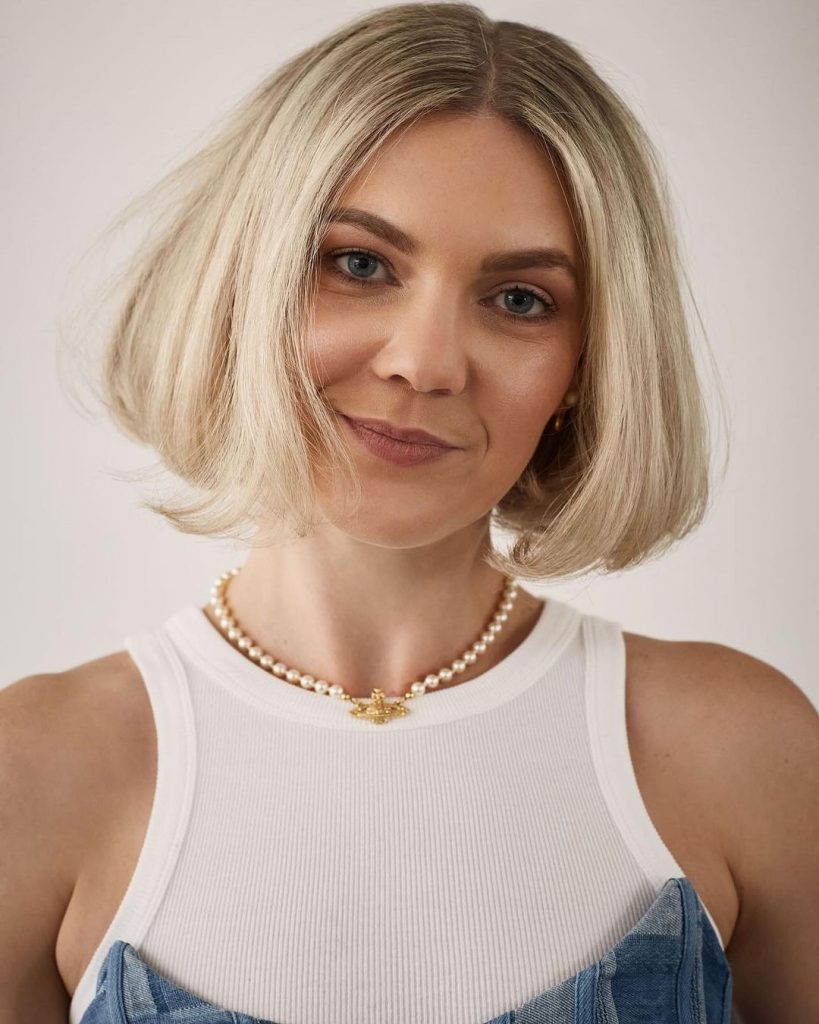 Mulher branca, loira, com cabelo curto escovado, no estilo bubble bob