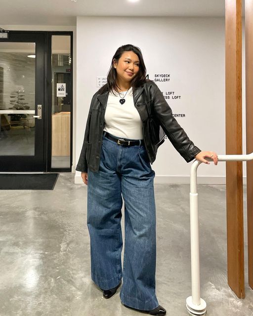 Moça jovem e midsize usando calça jeans e jaqueta de couro preta
