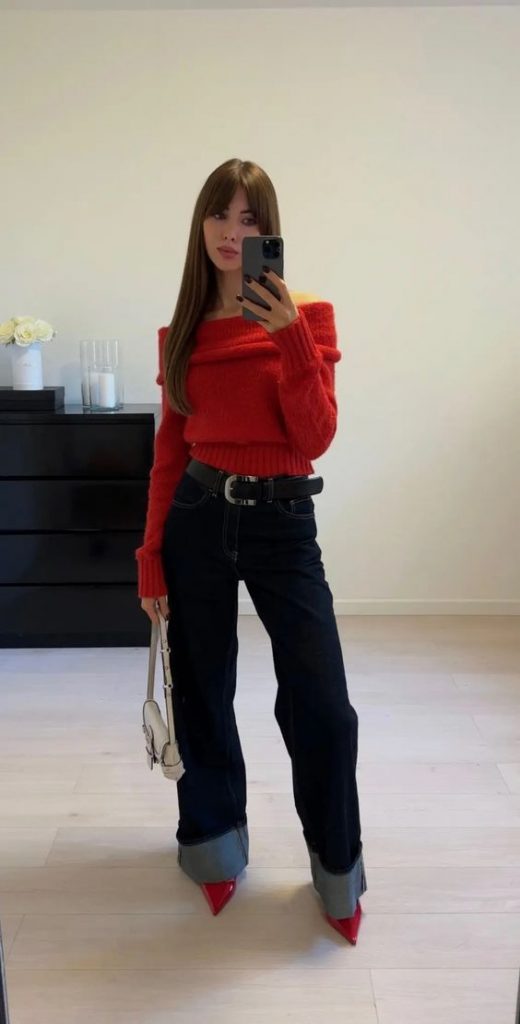 Mulher usando calça jeans, sapato de bico fino e suéter vermelho