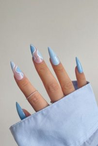 Mão branca com unha azul claro no formato stileto