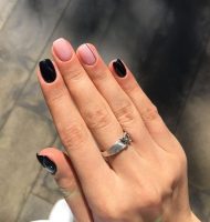 Mão branca com anel prata; Unhas pretas e nude