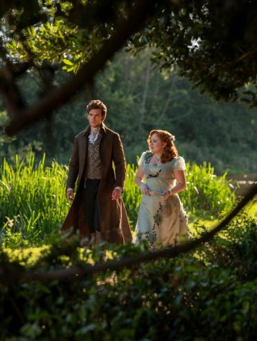 Penélope e Colin, de Bridgerton, ao fundo com uma paisagem de campo