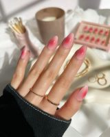 Mão branca com anéis e unha de aura rosa amendoada curta