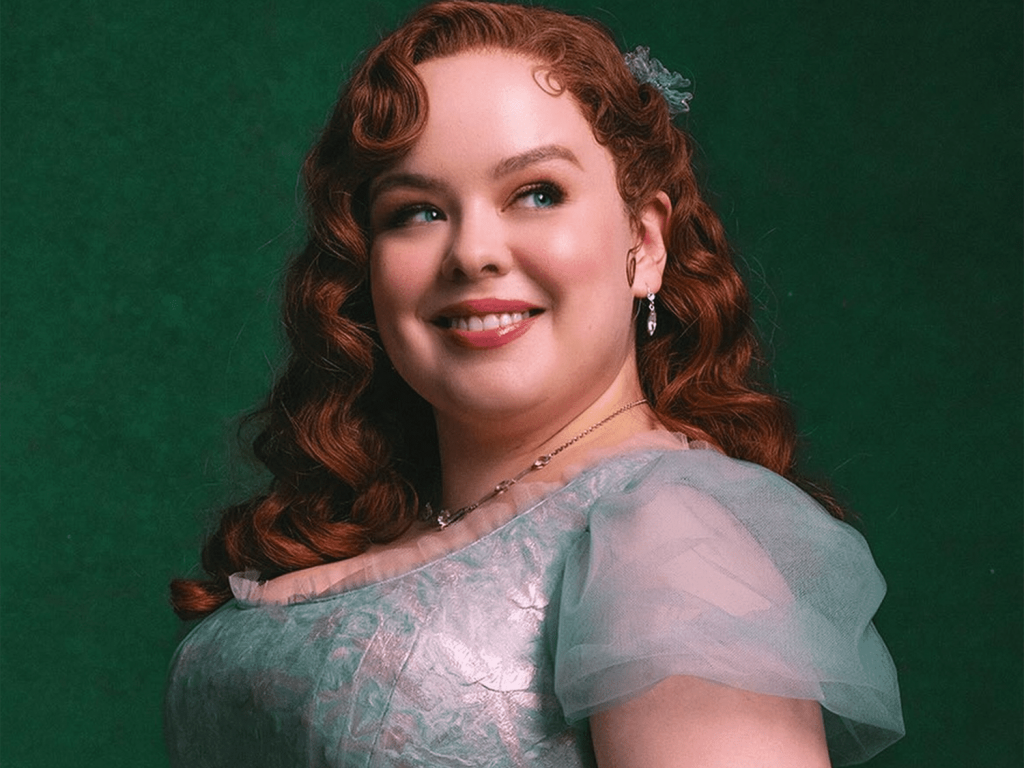 Penelope Featherington com cabelo cacheado ruivo e vestido verde