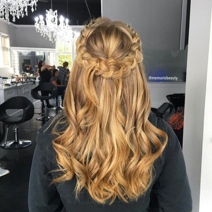 Mulher de costas com cabelo loiro ondulado com coroa de trança