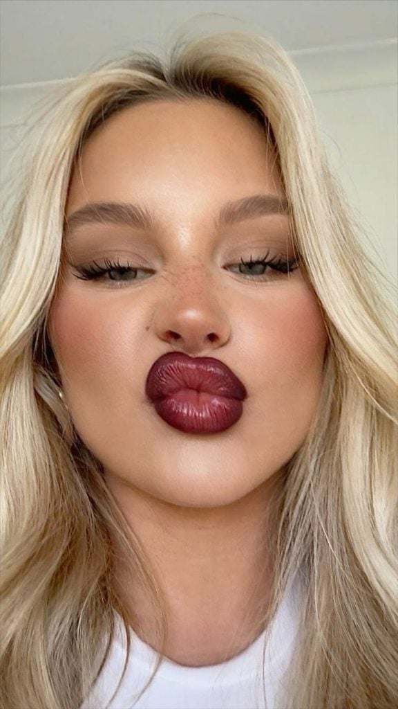 Mulher branca com cabelo loiro e cherry lips