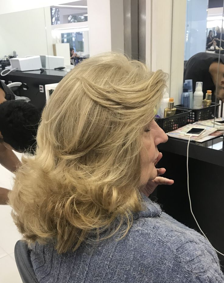 Mulher branca, de 50 anos, com cabelo longo e loiro, com corte butterfly cut