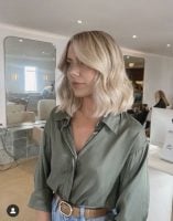 Mulher branca com cabelo loiro long bob e com franja