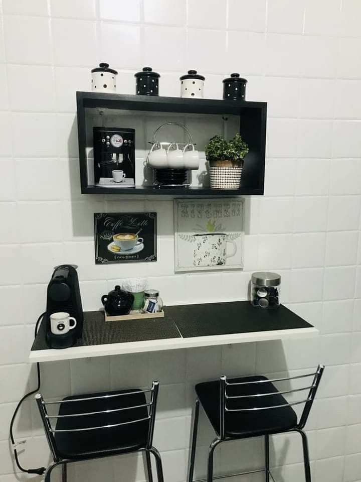 Cozinha preta e branca com mesa dobrável na parede