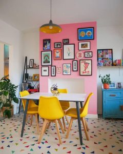 Cozinha com parede rosa e cadeiras amarelas