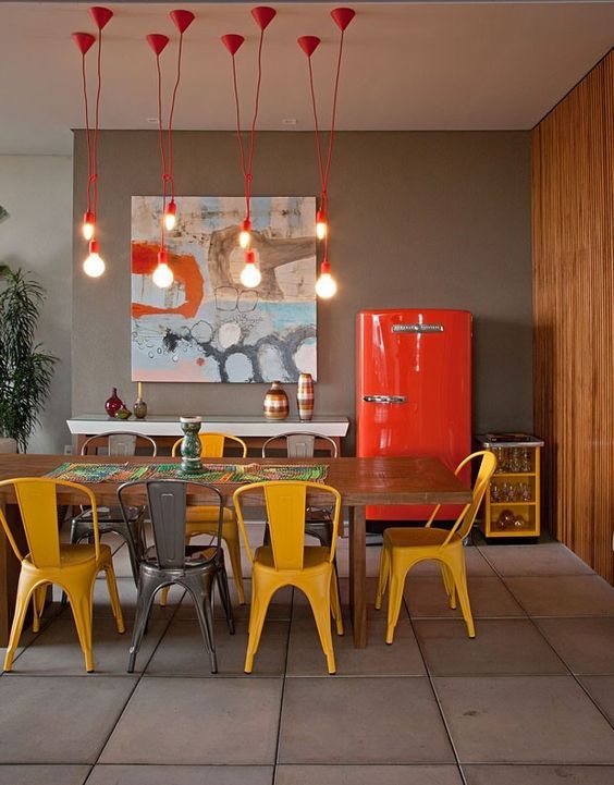 Cozinha com geladeira vermelha e cadeiras amarelas
