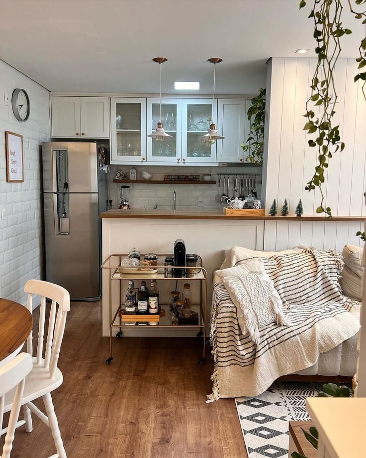 Sala e cozinha em tons neutros e com plantas