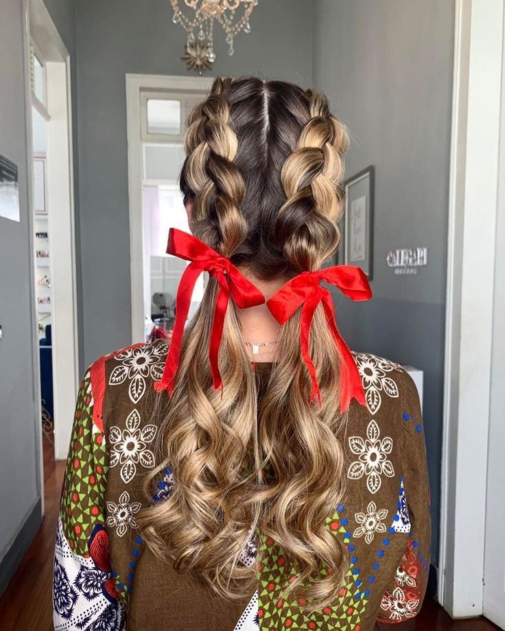Mulher de costas com cabelo loiro preso em uma trança embutida com laços vermelhos