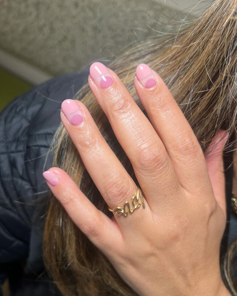 Mão branca com anel e unha almond curta com francesinha rosa invertida e design diferente