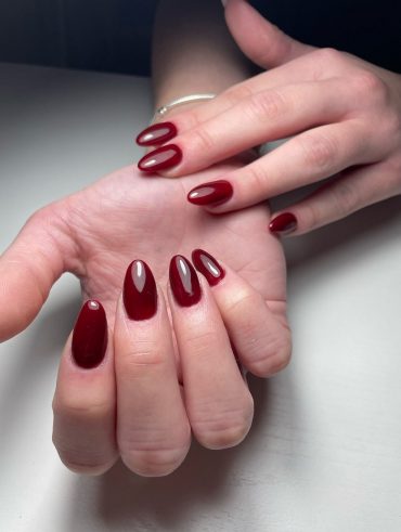 Mãos brancas com unha amendoada vermelho cereja