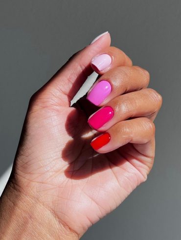 Mão branca curvada com unha rosa degradê