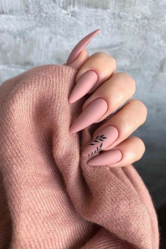 Mão branca curvada com unha stiletto rosa fosca com folha