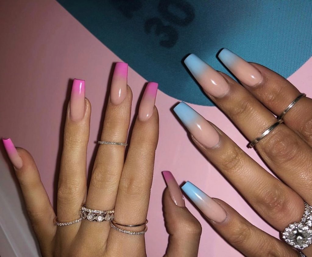 Mãos brancas abertas com anéis pratas e unha ombré rosa e azul