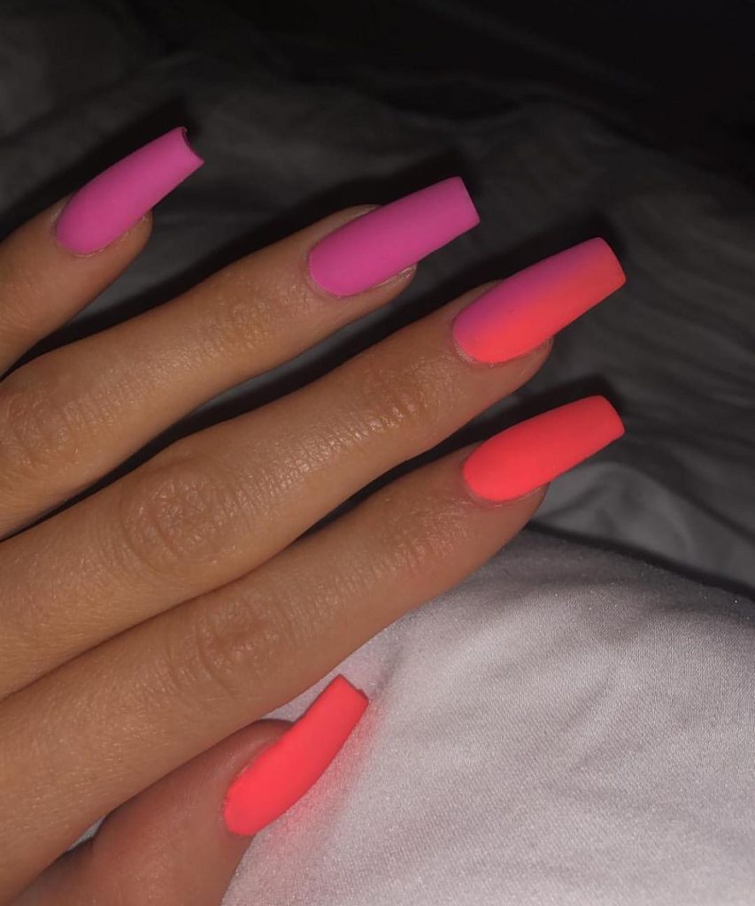 Mão branca com unha ombré rosa e laranja