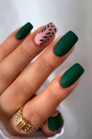 Mão branca com unha quadrada verde fosca com decoração de folha