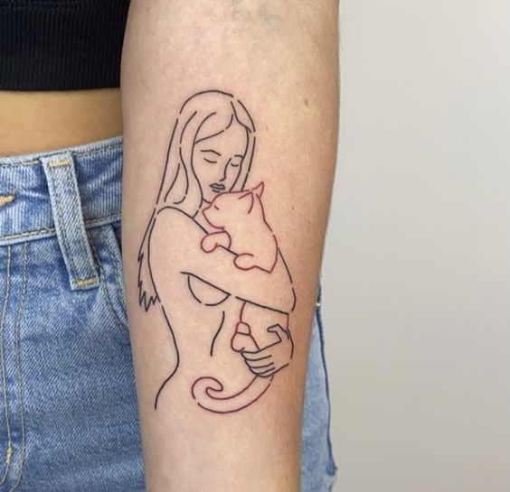 Braço com tatuagem em pele clara. O desenho conta com o contorno de uma menina e um gato em seu colo.