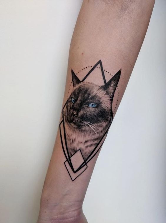 Tatuagem de gato em braço de pele clara.