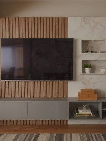 Sala de TV com painel ripado e revestimento marmorizado