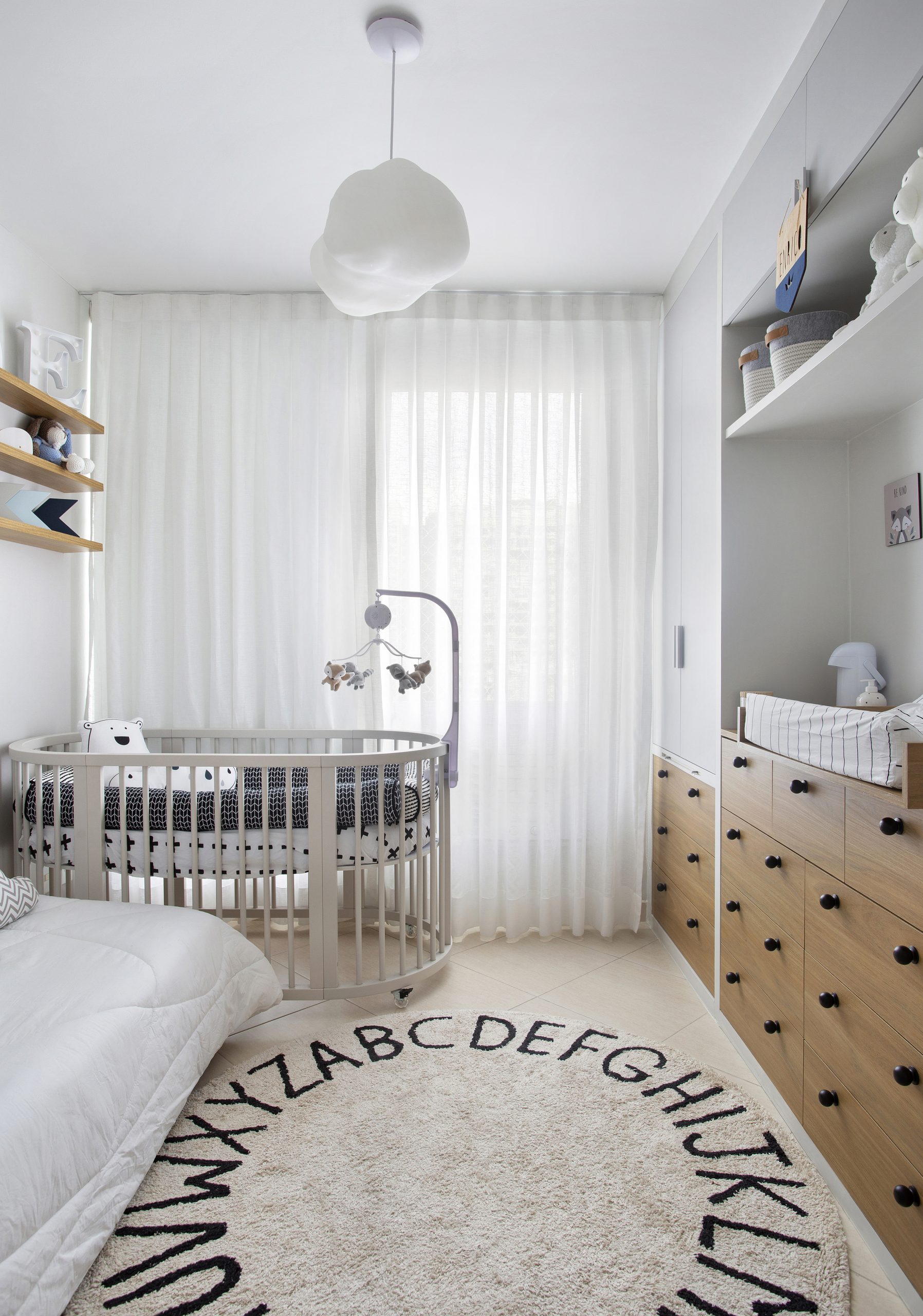 Quarto infantil em cores claras com pendente em formato de nuvem