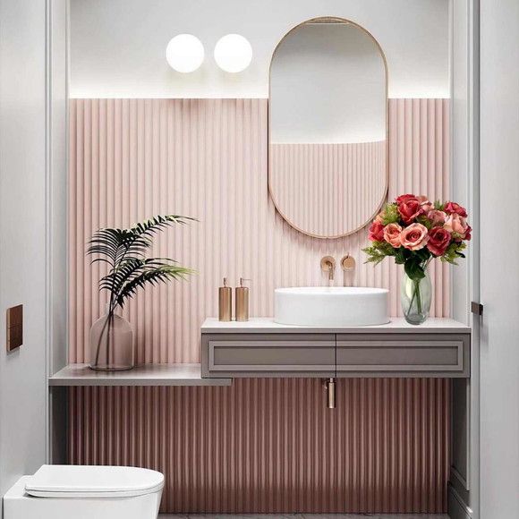 Banheiro com ripado rosa e espelho oval com borda em rose gold