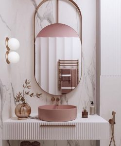 Banheiro com espelho oval e cuba rosa