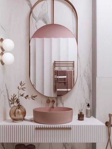 Banheiro com espelho oval e cuba rosa