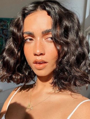 Mulher com corte de cabelo box bob, curto e ondulado
