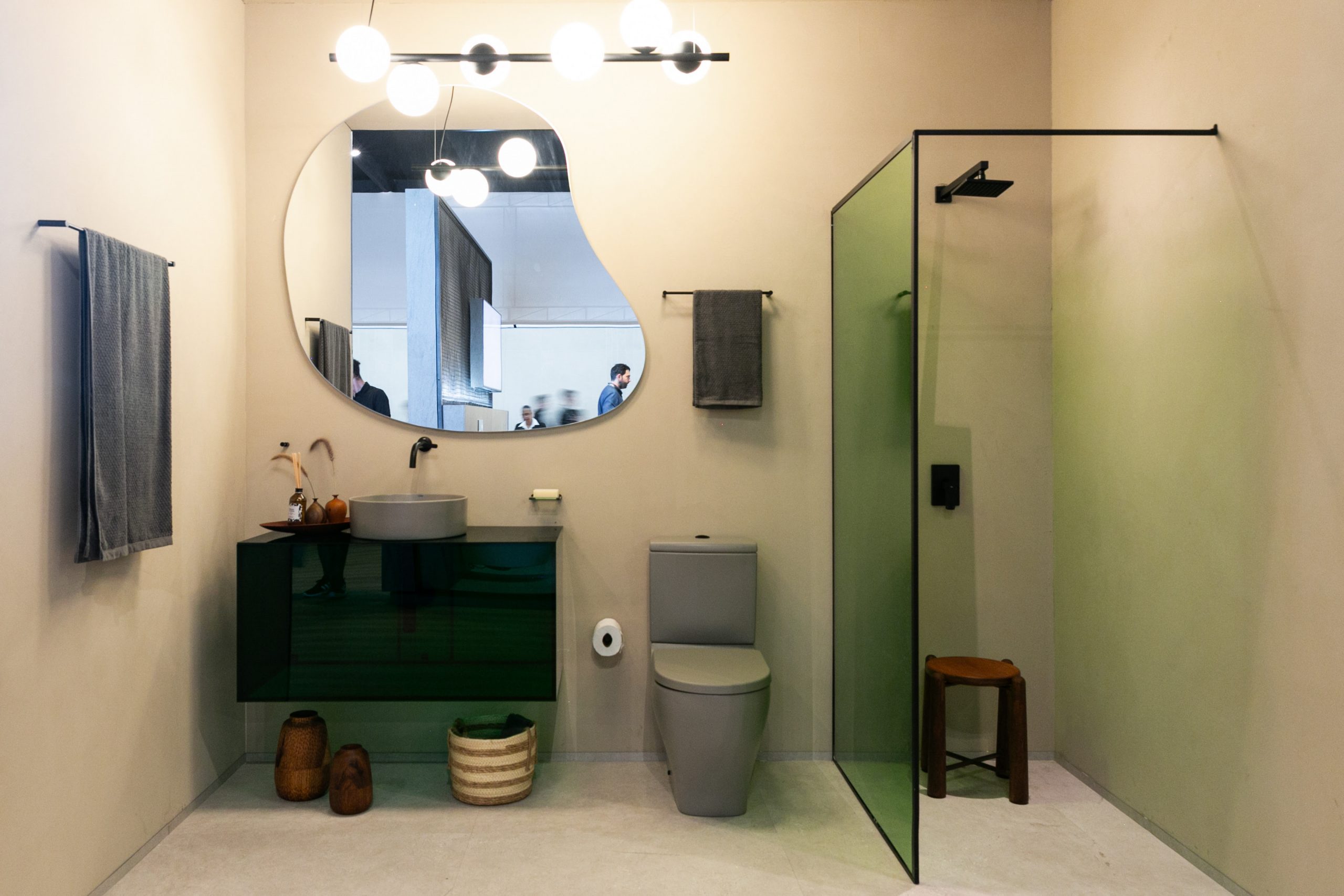 Banheiro com espelho orgânico, box e bancada em acrílico verde