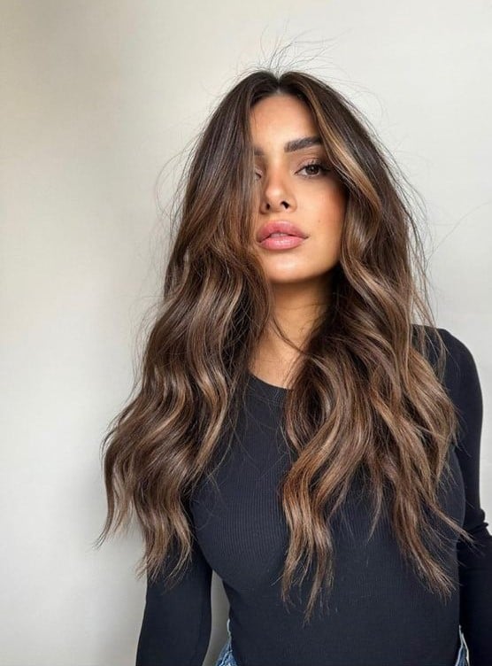 Mulher com cabelo longo na cor morena iluminada em tom claro